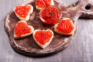 Red caviar over heart shape bread