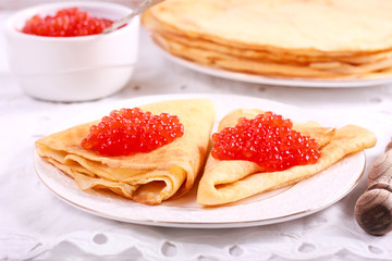 Thin pancakes with red caviar