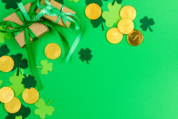 Saint Patrick's Day. Green three petal clovers and gold leprechaun  coins on green background