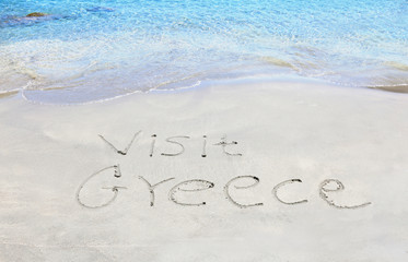 visit greece written on sand - greek summer photos