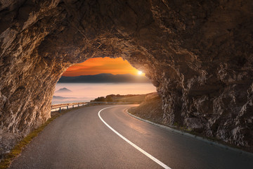 Old road tunnel in mountains at beautiful sunrise