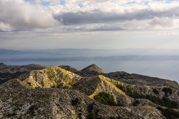 Panorama of mountain range in front of the Dalmatian coast of the Adriatic Sea in Biokovo Nature Park - View from Sveti Jure peak, Croatia, Europe