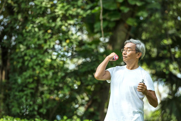 Older people are exercising healthy. Elderly man holding dumbbells. Soft focus concept.