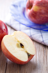 Fresh red apple and slice on a wooden table.