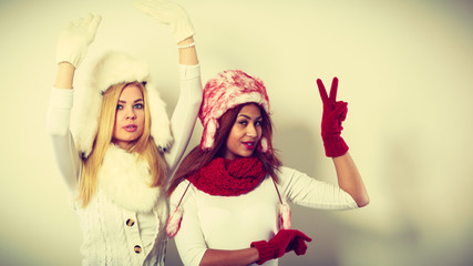 Two girls warm winter clothing having fun.