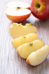 Fresh red apple and slice on a wooden table.