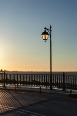 Street lamppost illuminated by setting sunlight