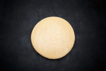 Whole round Head of parmesan or parmigiano hard cheese on concrete background