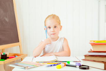 portrait of thoughtful little girl looking puzzled while doing homework at home