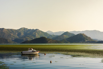 Boats on the shore of Shkoder Lake surrounded by mountains , Montenegro, Europe