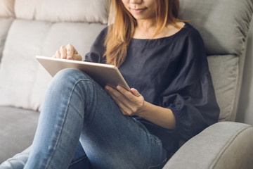 Young woman using tablet on sofa at home