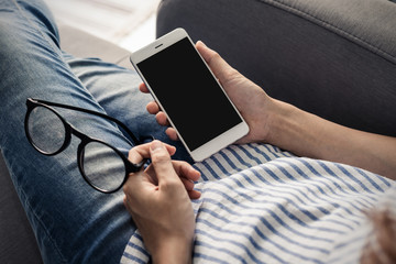 Young woman take off her glasses and siiting on sofa