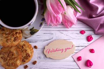Valentines day greeting card with pink tulips coffe cup cookies and lettering wishing you.