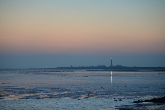 blaue Stunde über dem Watt vor Pellworm bei Ebbe mit Blick zum Leuchtturm