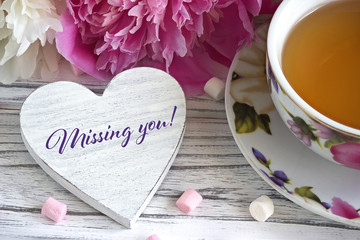 Valentines day greeting card with peonies tea cup marshmallow and lettering missing you.