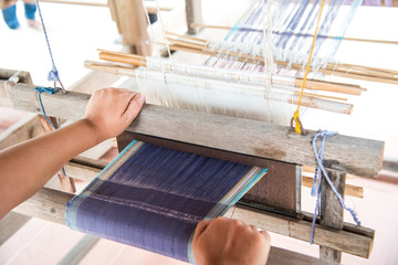 The hand of a weaver is woven with a hand-woven machine.