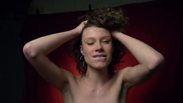 Curly brunette shows an orgasm and smiles