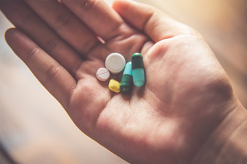 The hand is spread out and there are many medical different kinds of colors in it. To treat the disease