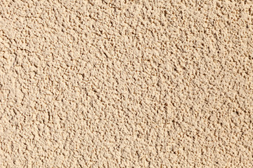 wall with a textured plaster of beige color. Background image, texture.