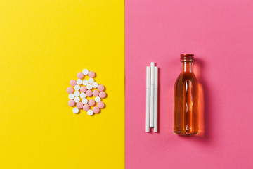 Medication colorful tablets pills arranged abstract, bottle of alcohol, cognac, whiskey, three...