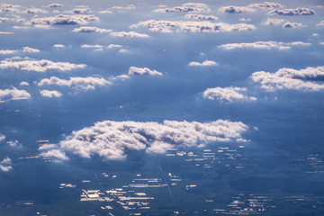 White clouds above earth seen from plane window