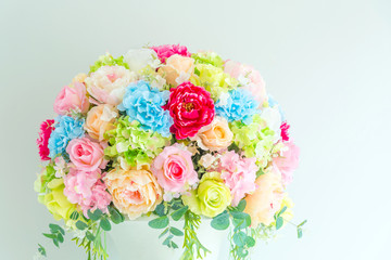 colorful paper roses decorated with the green wall in a wedding reception