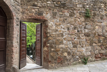 Open door on ancient brick wall