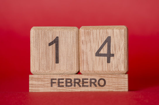 Big wooden cubes forming the number fourteen and little rectangle with the word febrero against red background for Valentine's Day
