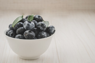 Fresh raw organic blueberry in white cup on white background/Fresh raw organic blueberry in white cup on white background. copy space. Toned