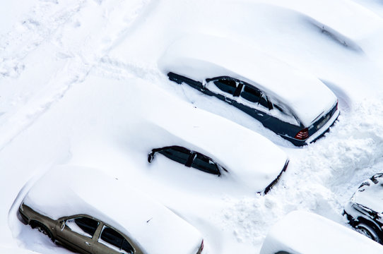 After a snowstorm, cars in the parking lot are covered with a thick layer of snow