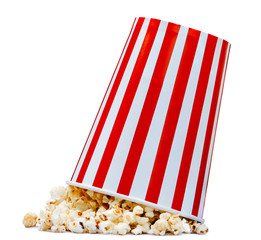Isolated popcorn in striped bucket fall to the ground on white background