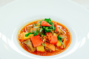 exquisite goulash grapes in a white plate background of table setting, cozy restaurant serving close-up