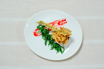 delicate exquisite salad with migdal arugula turkey sun-dried tomatoes and greens in a white plate on a white tablecloth