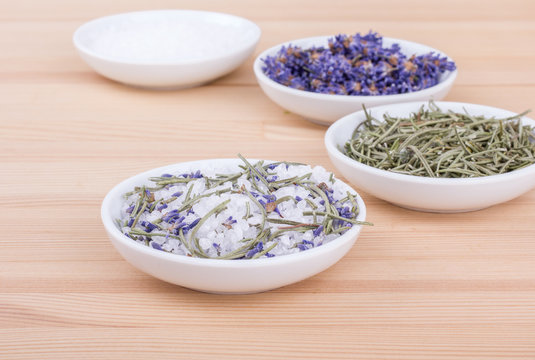salt with rosemary and lavender / Herbal salt with rosemary and lavender blossoms on a wooden background 