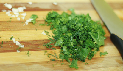 Cutting parsley and garlic on the wood desk