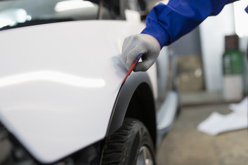 Fototapeta premium Car wrapping specialist putting vinyl foil or film on car. Selective focus. 