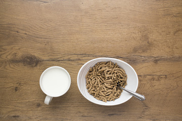 white bowl of healthy cereals with milk on wooden background