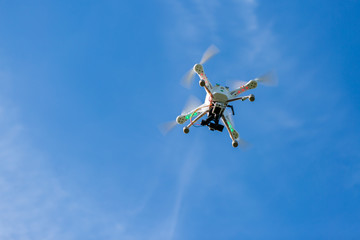 Flight of the drone in the blue sky, view of the drone from below