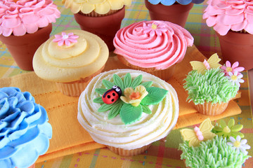 Decorated Easter cupcakes with flowers and a ladybug.