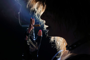 femme punk fumant une cigarette cheveux longs 