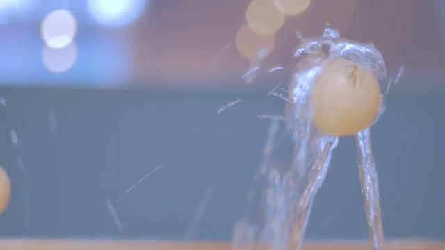 Woman hand putting tennis ball on jet of water. Science, physics and hydrodynamic concept