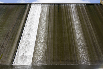 White water overspill run off on the stark sunlit concrete wall of Llys y Fran Reservoir Dam, Pembrokeshire, Wales, UK