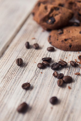 broken chocolate chip cookies with coffee beans on white wooden table