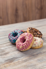 glazed donuts with sprinkles on a white wooden table