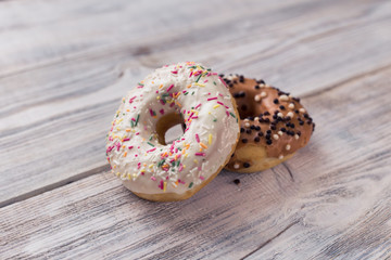 glazed donuts with sprinkles on a white wooden table