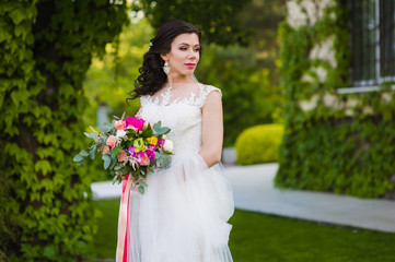Beautiful brunette bride with veil and bouquet