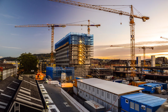 Baustelle am Abend, Neubau mit Baukran bei Sonnenuntergang