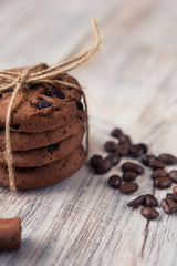 chocolate chip cookies tied with twine with coffee beans and cinnamon stick on white wooden table