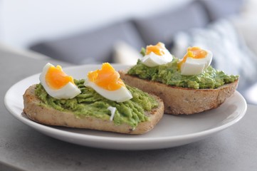 cereal bread with avocado spread and egg on white plate, healthy breakfast, vegetarian food - 191789343