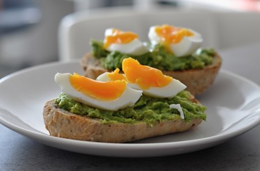 cereal bread with avocado spread and egg on white plate, healthy breakfast, vegetarian food - 191789346